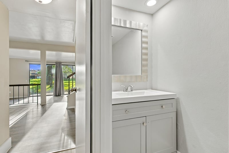 Hallway with mirror and vanity near railing at 7703 Las Palmas Way