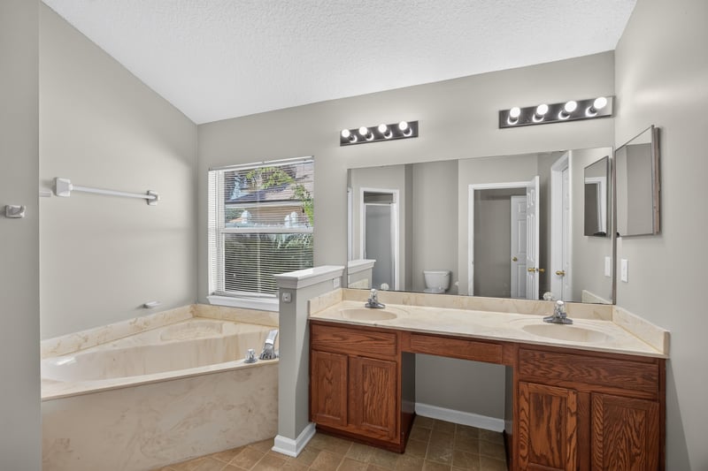 Bathroom with garden tub and dual-sink vanity at 14147 Fish Eagle Dr E, Jacksonville, FL 32226