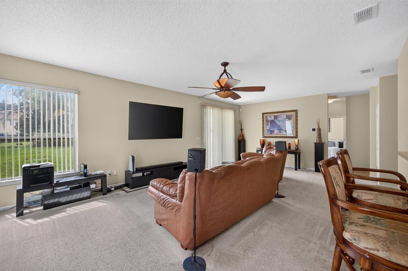 Family room with large window and carpet at 2875 Pebblewood Ln, Orange Park, FL 32065