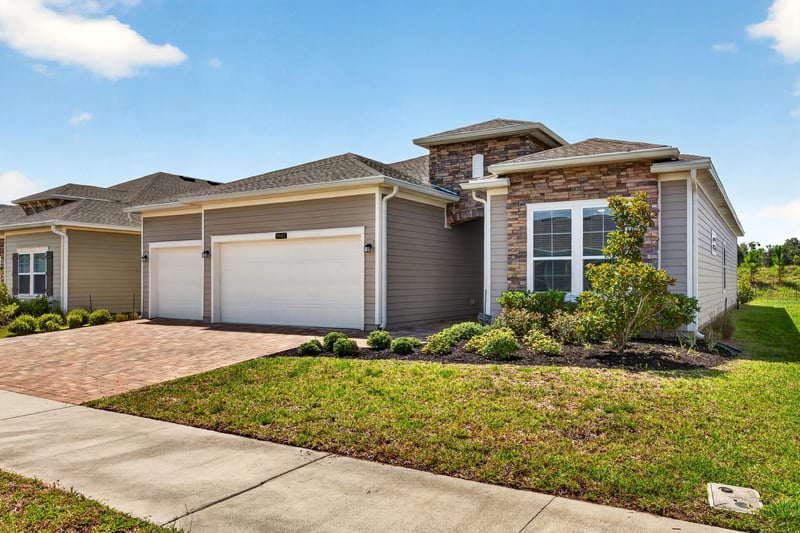 Front exterior with paver driveway and sidewalk at 9942 Lovage Ln, Jacksonville, FL 32219