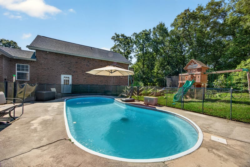 Backyard pool with playground and fenced yard at 1735 Hagans Ridge Ct