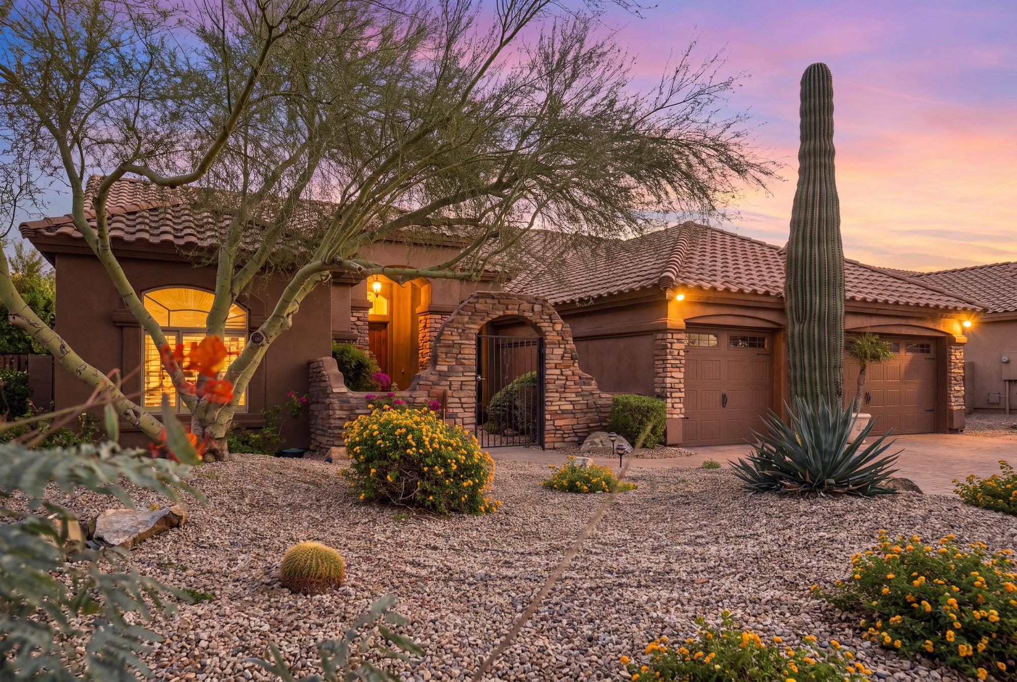 Virtual twilight of a desert front yard with a saguaro and a stone entry