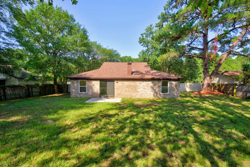 Backyard view with trees and open lawn at 8453 Boysenberry Ln W, Jacksonville, FL