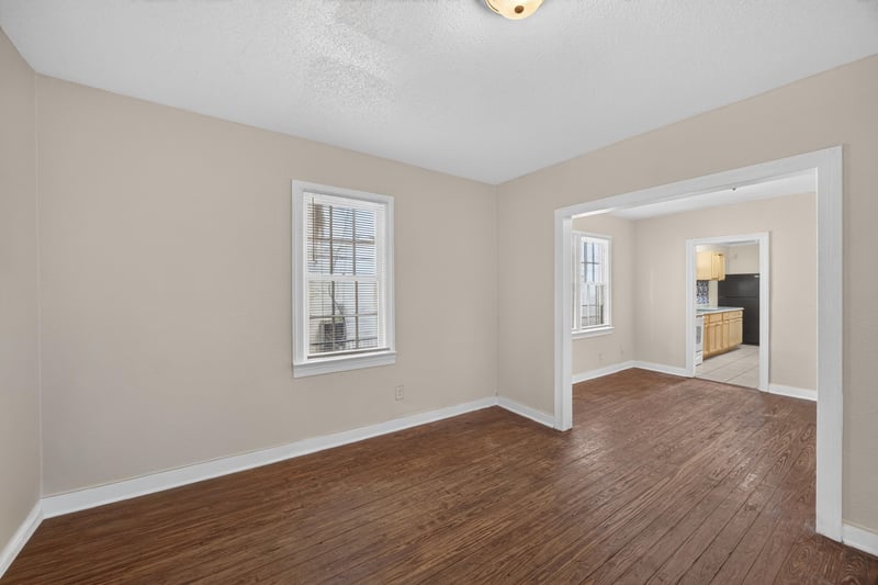 Living room with wood floors opening to adjoining room at 1473 State St W, Jacksonville, FL 32209