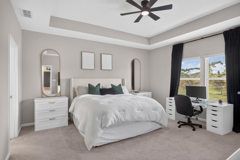 Primary bedroom with desk and tray ceiling at 9942 Lovage Ln, Jacksonville, FL 32219