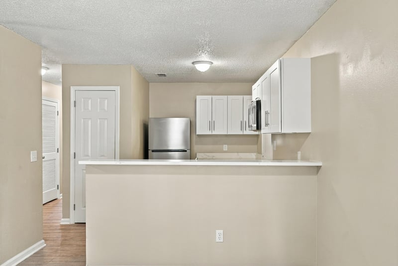Kitchen pass-through counter with white cabinets at 219 Shortreed St, Jacksonville, FL 32254