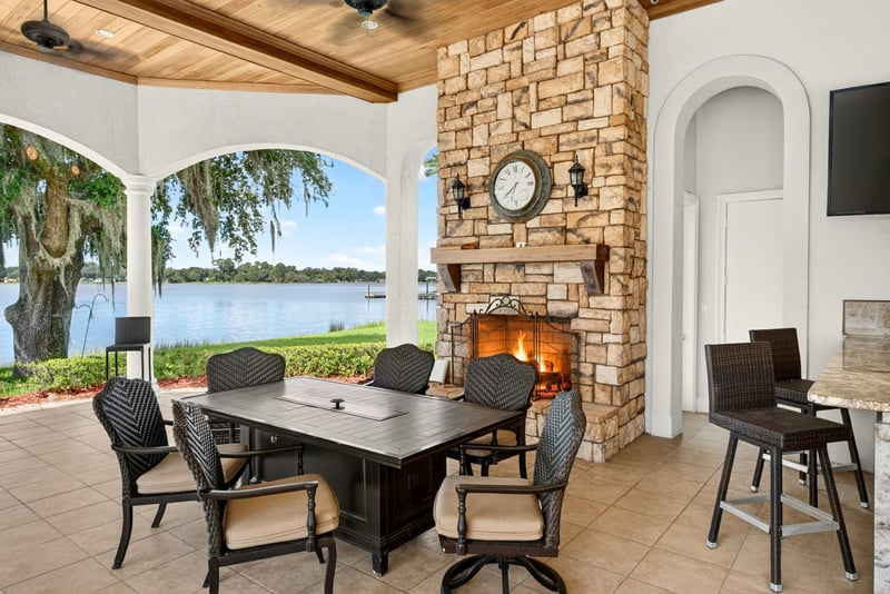 Outdoor dining area with stone fireplace and lake view at 344 Broward Rd, Jacksonville, FL