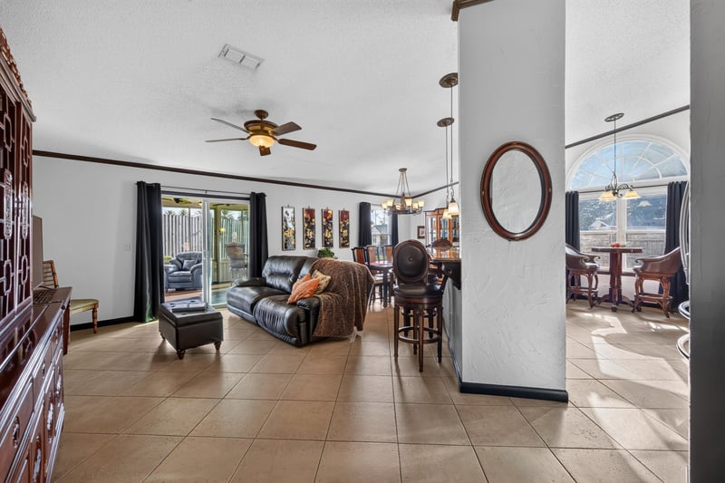Living room with vaulted ceiling and fan at 6931 Cane Grass Ln E, Jacksonville, FL 32244