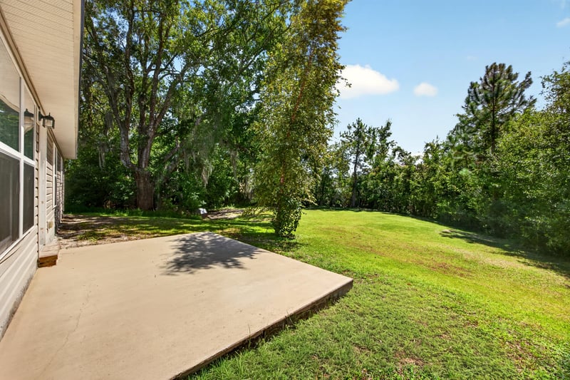 Backyard with concrete patio and open lawn at 9846 Olivia St, Jacksonville, FL
