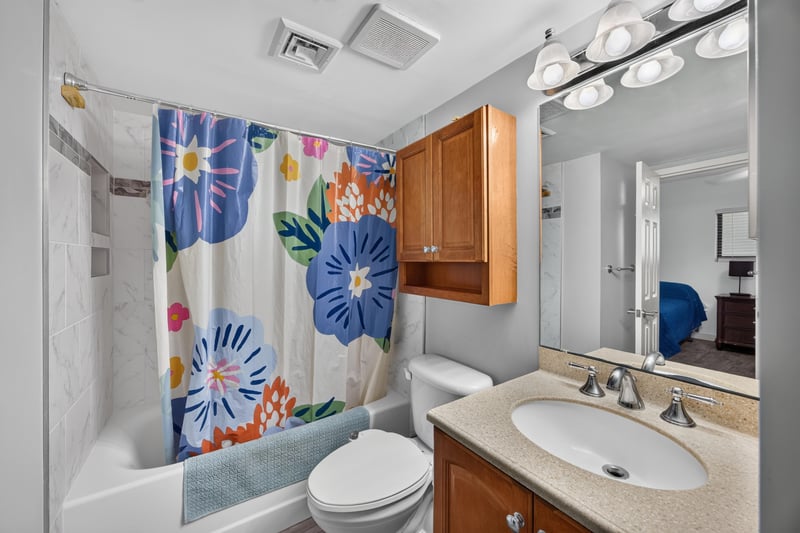 Bathroom tub and shower with floral curtain at 601 1st St S, Jacksonville Beach