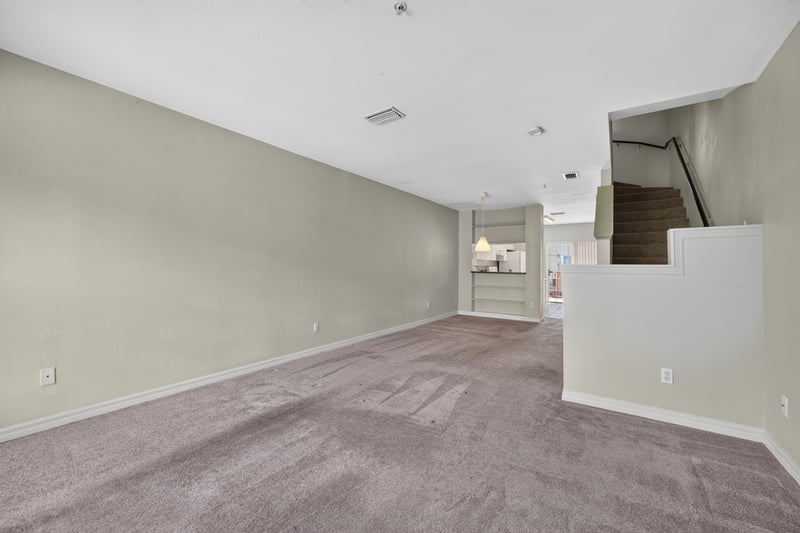 Open living area with carpet and staircase at 342 E Ashley St, Jacksonville, FL 32202