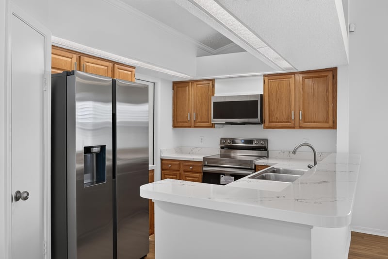 Kitchen with stainless refrigerator and wood cabinets at 8047 Mactavish Way E, Jacksonville, FL 32244