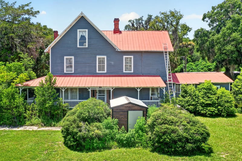 Aerial view of the wraparound porch and red metal roof at 1173 US-17, Satsuma, FL 32189