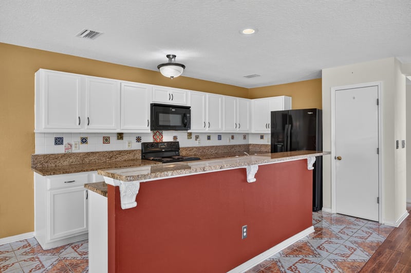Kitchen with white cabinets and red island at 2282 Justin Lake Dr, Jacksonville, FL
