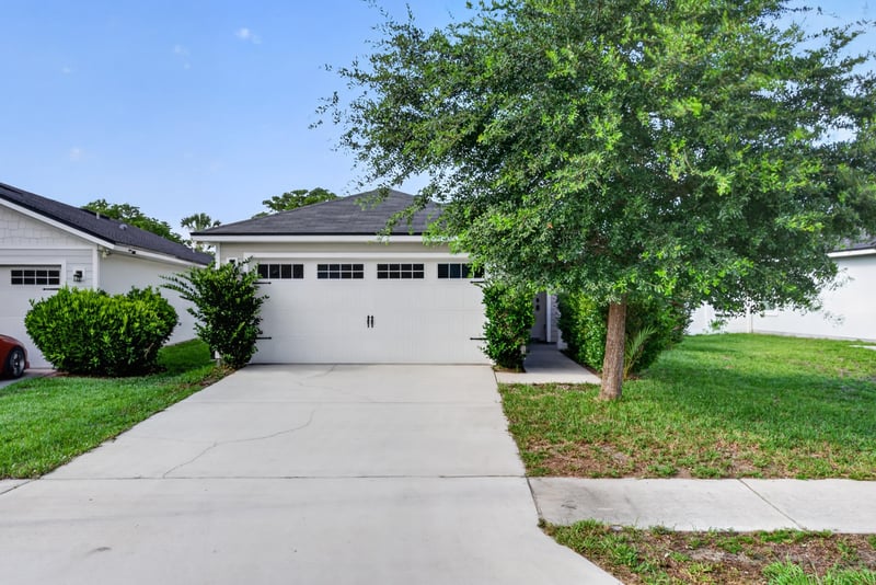 Front exterior, daytime, garage door and shade tree at 7253 Townsend Village Ct, Jacksonville, FL