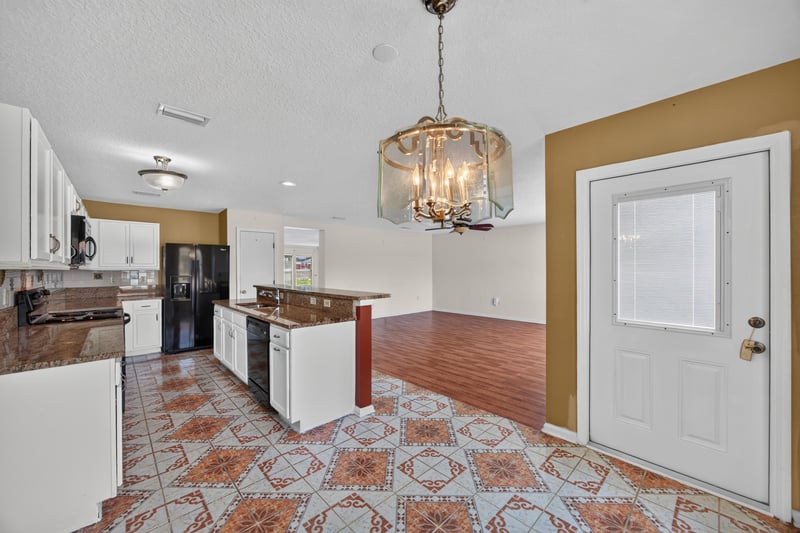 Kitchen and living area with door to backyard at 2282 Justin Lake Dr, Jacksonville, FL