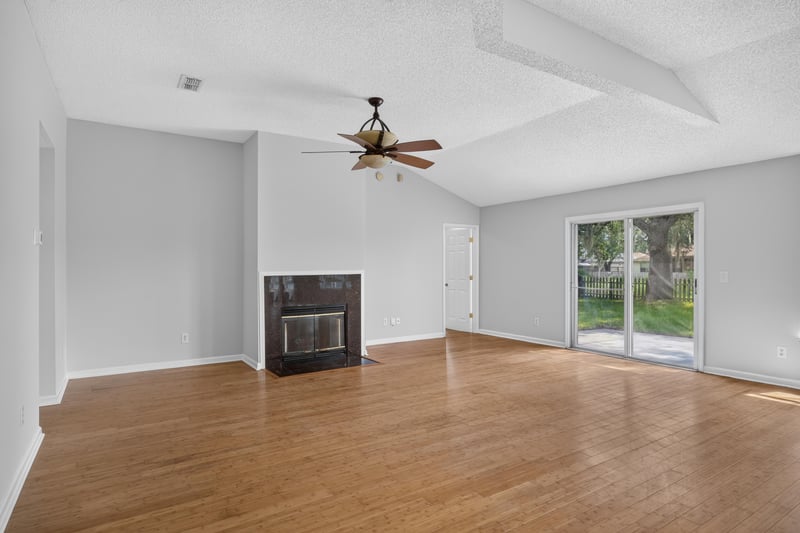 Living room with fireplace and sliding glass doors at 456 Bay Point Way N, Jacksonville, FL 32259