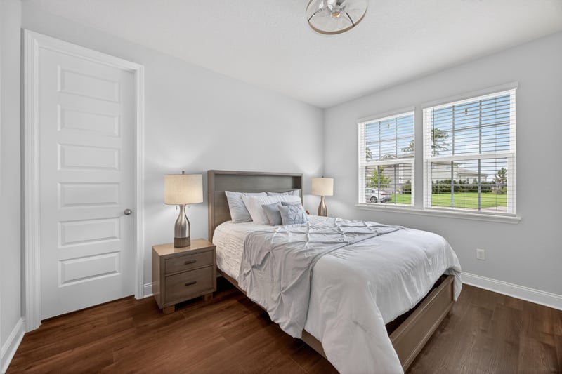 Bedroom with wood floors and bedside lamps at 85491 Fall River Pkwy, Fernandina Beach, FL 32034
