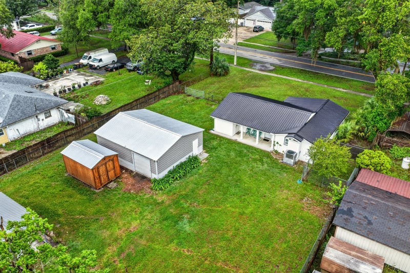 Aerial view of backyard sheds and surrounding trees at 1619 Hammond Blvd, Jacksonville, FL