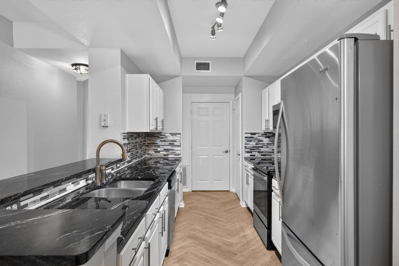 Kitchen with dark granite counters and stainless refrigerator at 10075 Gate Pkwy unit 1905, Jacksonville, FL 32246