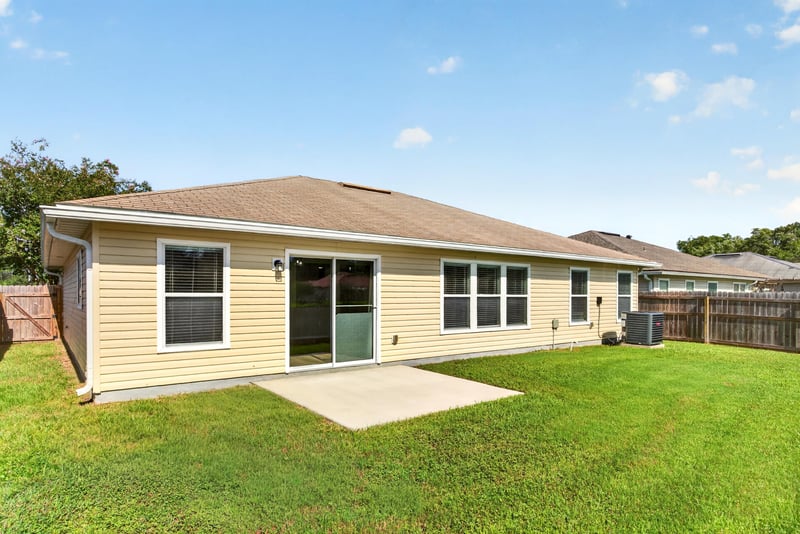 Rear patio with sliding glass door at 7545 Lirope St, Jacksonville, FL 32244