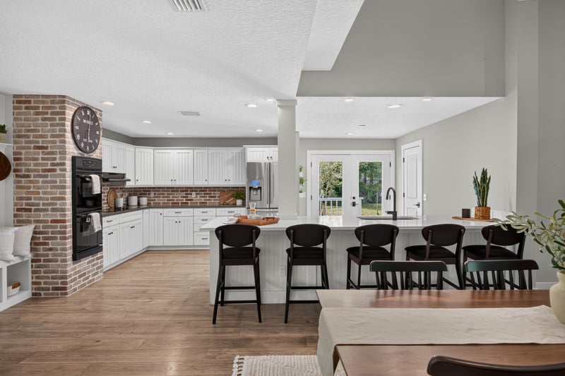 Kitchen island with dining and living room beyond at 1161 Whispering Pines Rd, Jacksonville, FL 32259