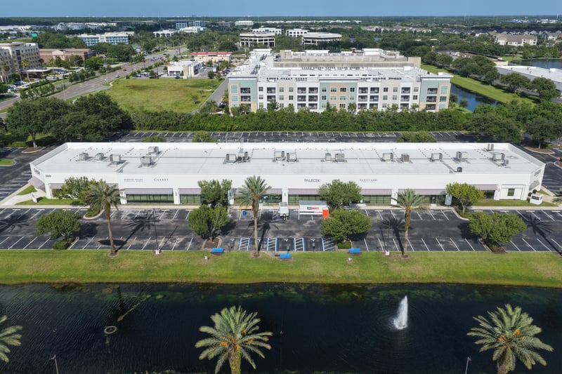 Aerial view of a roofline with multi-story building and pond beyond at 10550 Deerwood Park Blvd, Jacksonville, FL 32256