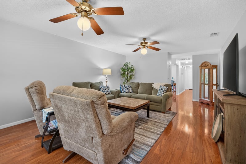 Living room seating area with ceiling fan at 2435 Range Line Rd, Middleburg, FL