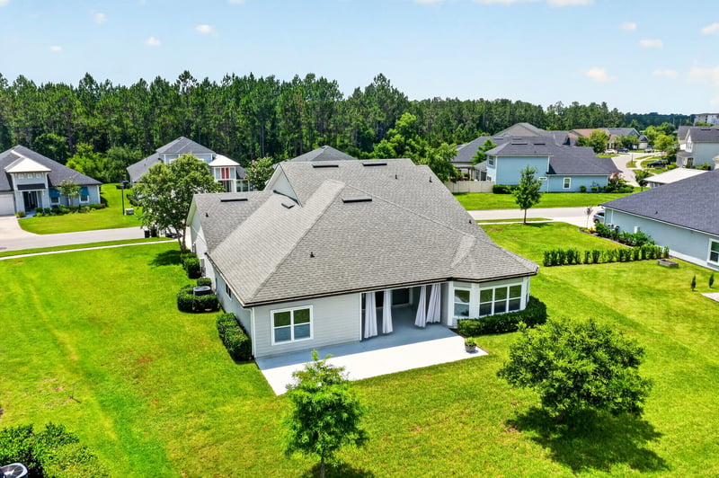 Aerial view of home with covered back porch near pond at 53 Lumen Ct, St. Augustine, FL 32095