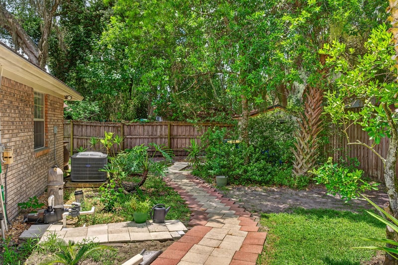 Backyard brick pathway and landscaping at 12810 Swamp Owl Ln