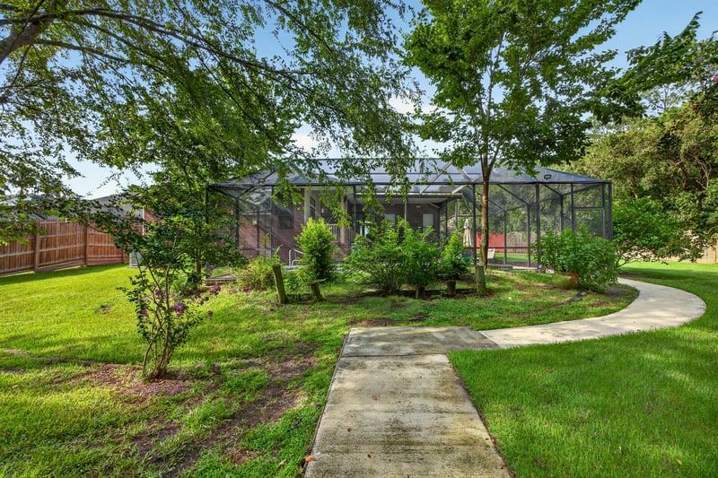 Backyard with screened structure and stone path at 2125 Blue Heron Cove Dr, Orange Park, FL 32003