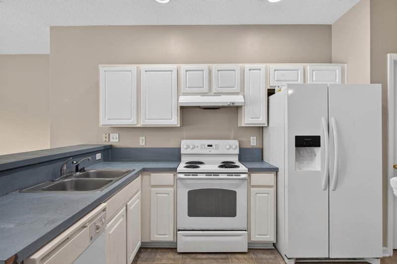 Kitchen with white cabinets and dark countertops at 1572 Biscayne Bay Dr, Jacksonville, FL 32218