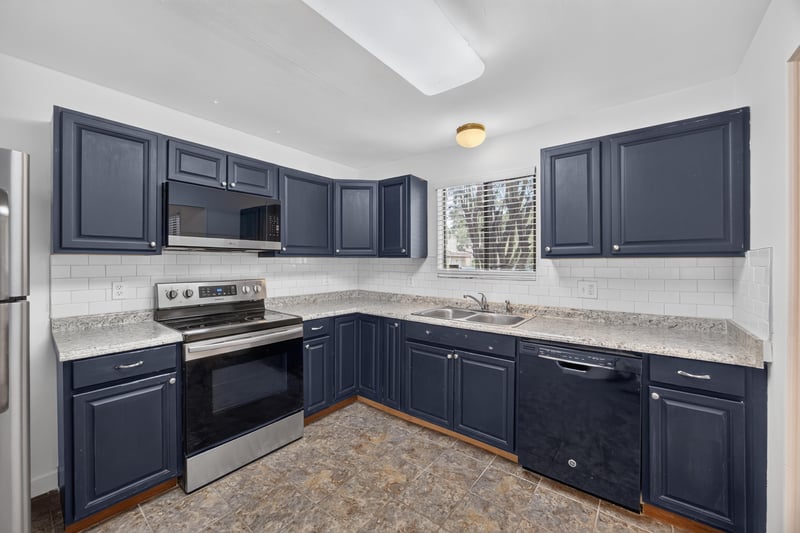 Kitchen with navy cabinets and stainless refrigerator at 3801 Crown Point Rd unit 2061, Jacksonville, FL 32257