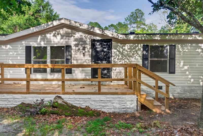 Front exterior with wood ramp and black shutters at 55520 Jewel-Thomas Rd, Callahan, FL 32011