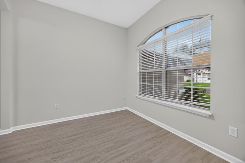 Empty room with arched window and wood-look floor at 706 Bonaparte Dr, Jacksonville, FL 32218