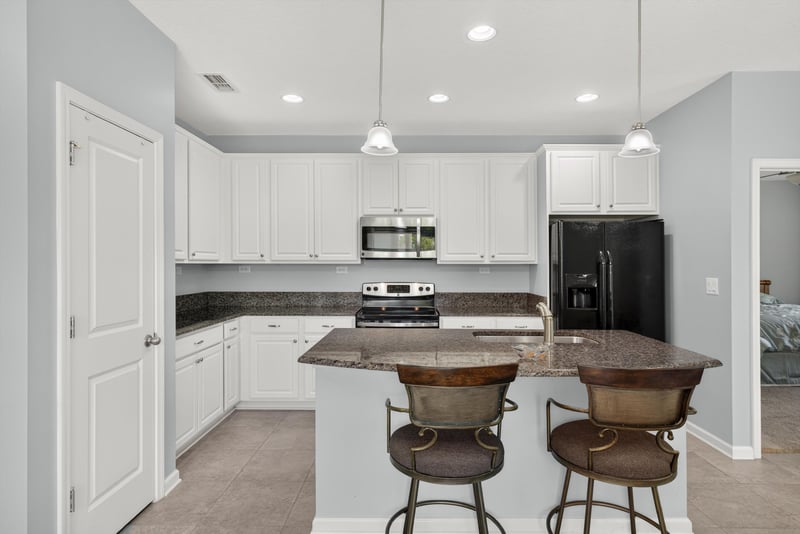 Kitchen with white cabinets, black appliances and island at 2378 Caney Oaks Dr, Jacksonville, FL