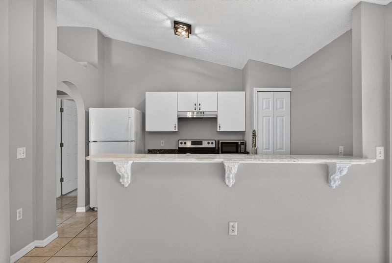 Kitchen with white cabinets and stainless range at 7329 Lawn Tennis Ln, Jacksonville, FL