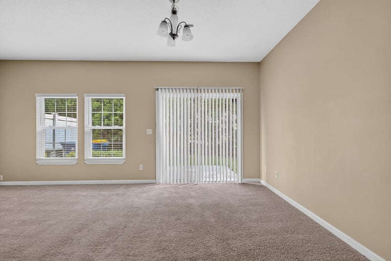 Living room with carpet and sliding glass door at 12359 Mangrove Forest Ct, Jacksonville, FL 32218