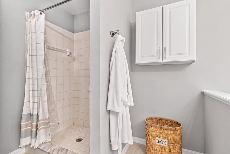 Primary bathroom shower with tile surround at 11197 Illford Dr