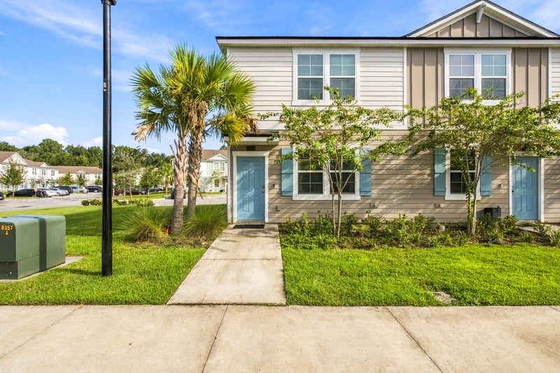 Walkway to front door with teal door and palm tree at 8359 Zenith Cir, Jacksonville, FL 32256