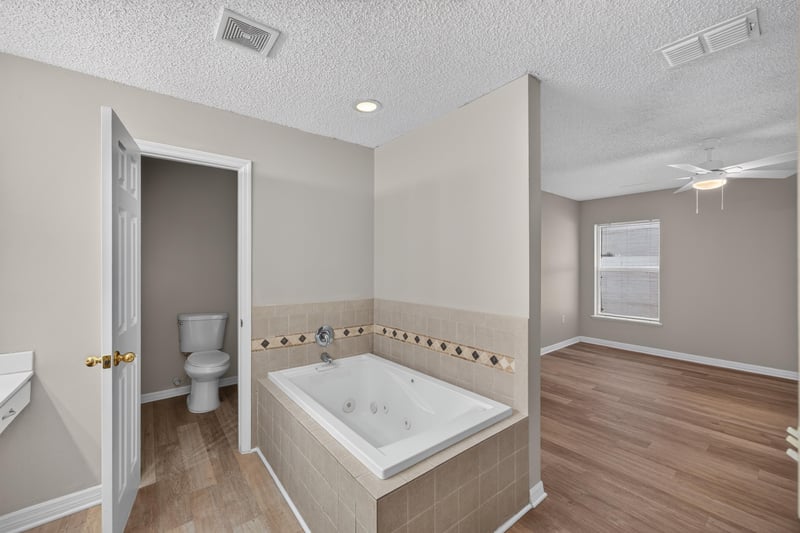 Primary bath with garden tub and window at 1845 Saga Ct, Middleburg, FL
