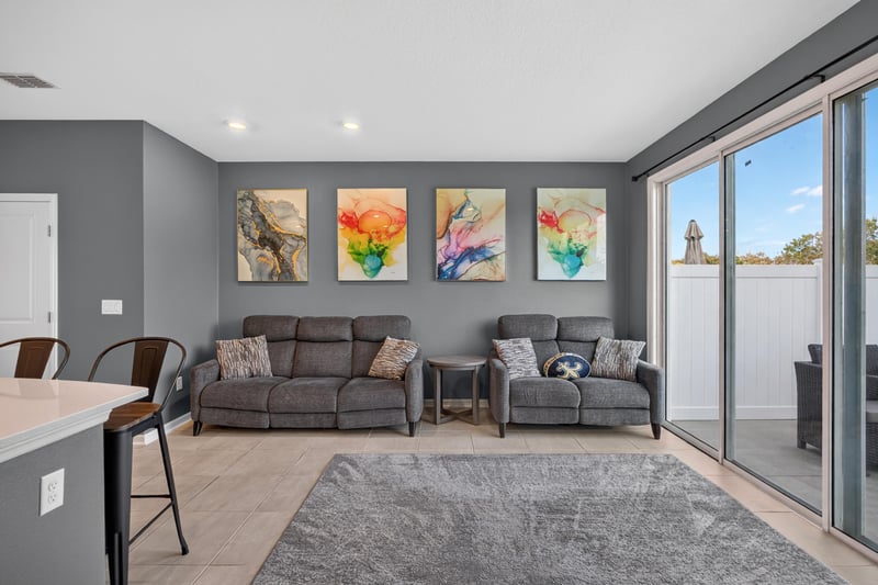 Living room with gray sofas and sliding door to backyard at 339 Anthony Dr, Jacksonville, FL