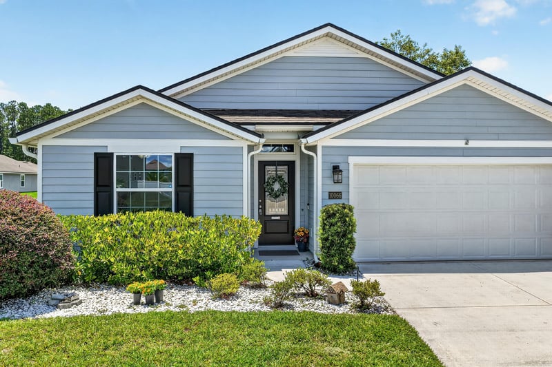 Front exterior with covered porch and shrub landscaping at 10066 Andean Fox Dr, Jacksonville, FL 32222