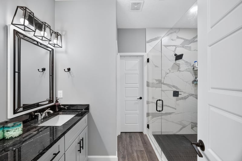 Bathroom vanity with black countertop and mirror at 2817 Camel Cir, Middleburg, FL