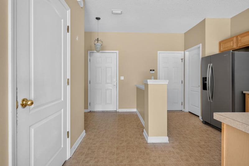 Kitchen peninsula with refrigerator and tile floor at 12359 Mangrove Forest Ct, Jacksonville, FL 32218