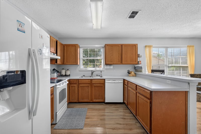 Kitchen with L-shaped counter and cabinets at 8680 Bandera Cir S, Jacksonville, FL 32244