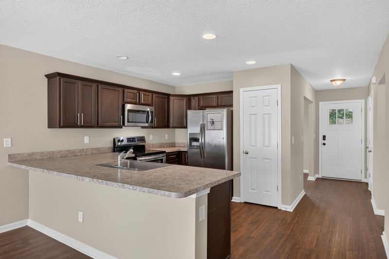 Kitchen island with granite-look counter and pantry door at 7253 Townsend Village Ct, Jacksonville, FL