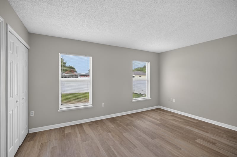 Bedroom with two windows and wood-look floor at 1845 Saga Ct, Middleburg, FL