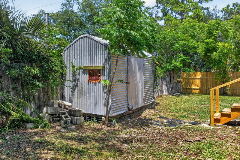 Backyard metal shed and wood fence at 7603 Coach Park Dr, Jacksonville, FL 32244