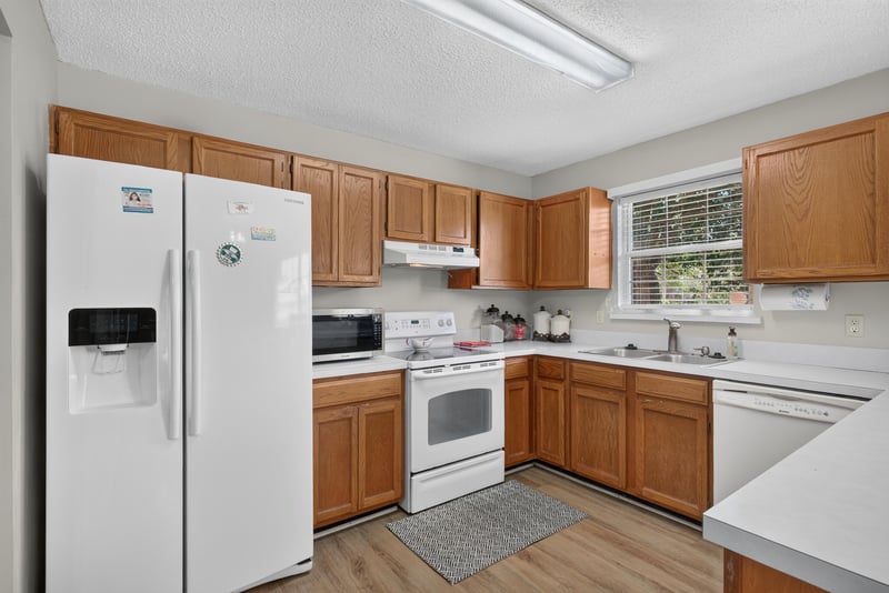 Kitchen with white appliances and wood cabinets at 8680 Bandera Cir S, Jacksonville, FL 32244